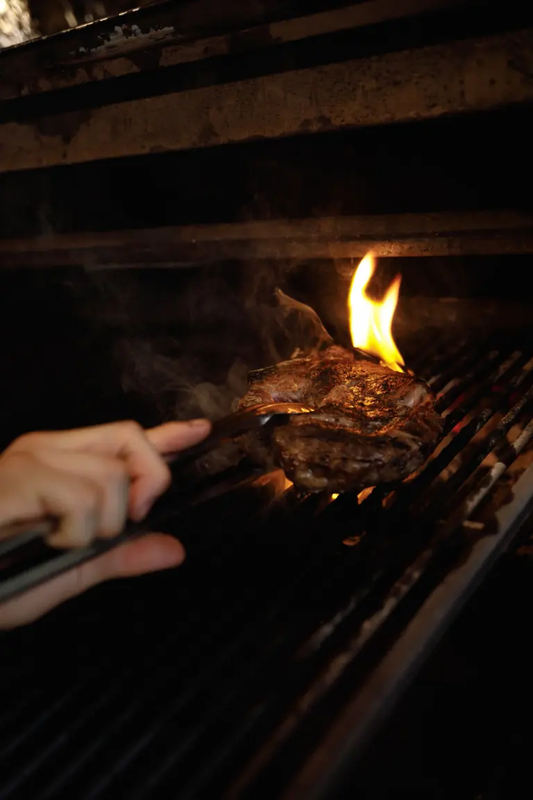 Steak nad plameny grilu na dřevěném uhlí